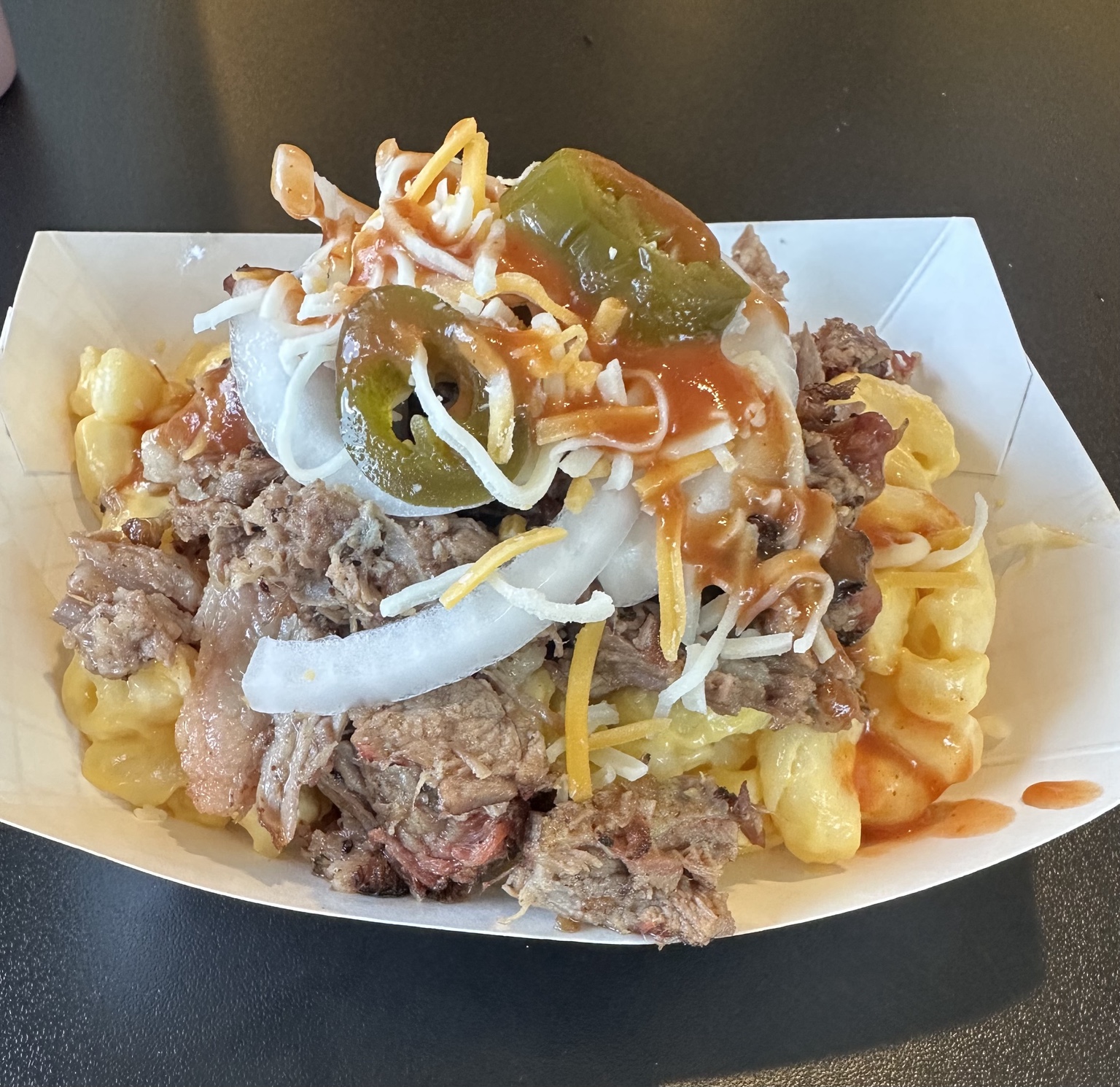 Softail loaded mac and cheese topped with brisket, cheese, onions, jalapeños and sauce